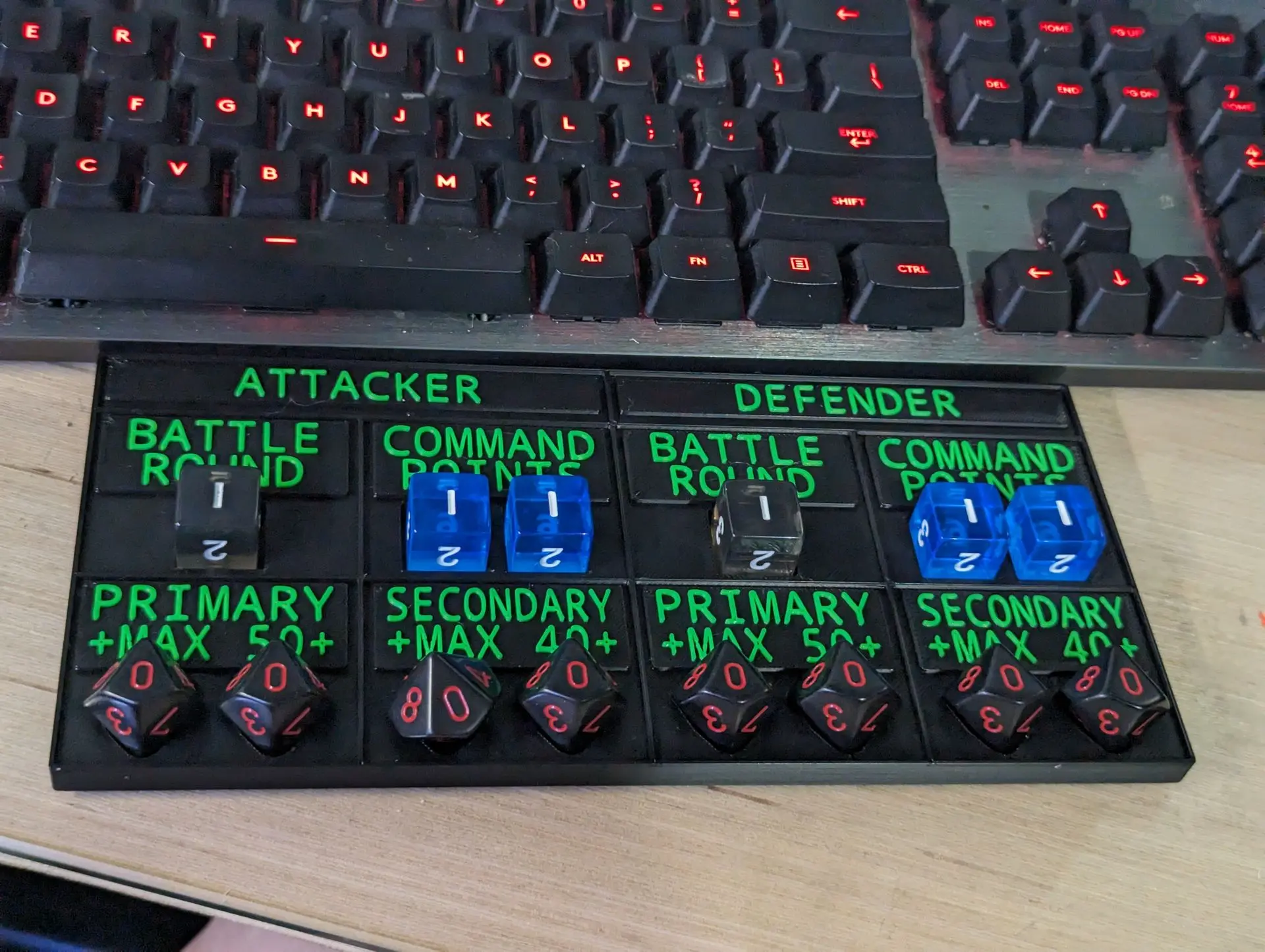 Custom 3D-printed tabletop game tracker panel with engraved ATTACKER/DEFENDER labels and dice wells, FDM print